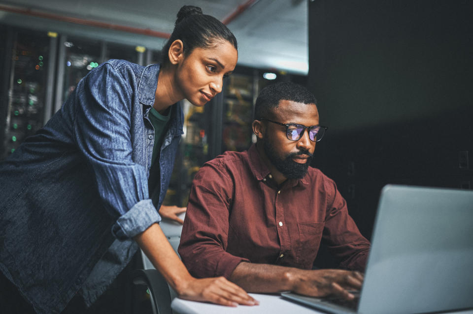 A man and woman using a laptop