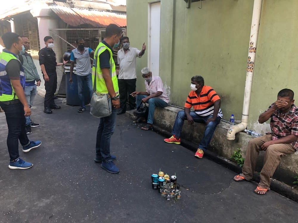 Four Malaysians and one Indian national were gathered together holding cans of alcohol at the narrow side lane off Burma Road when authorities chanced upon them. — Picture courtesy of Royal Malaysia Police