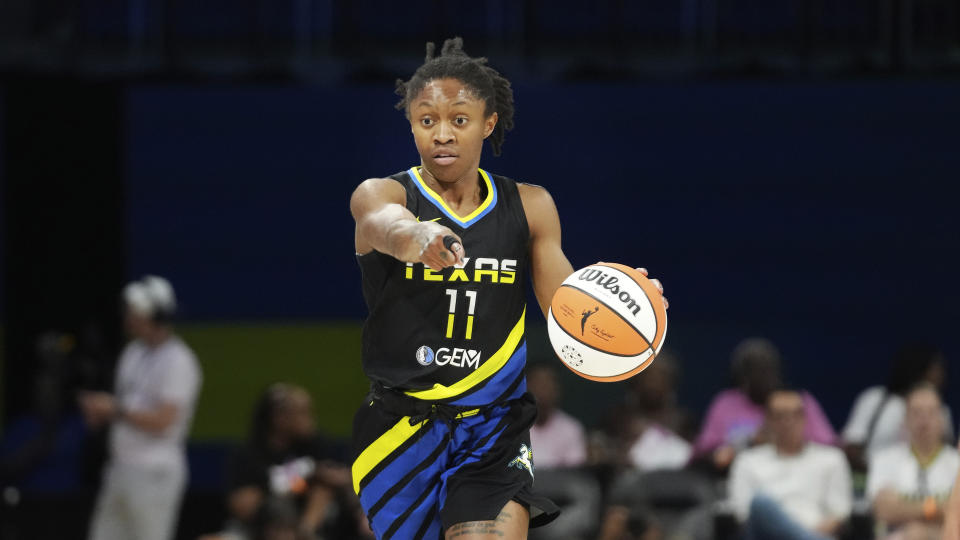 Dallas Wings guard Crystal Dangerfield (11) points during the first half of a WNBA basketball basketball game against the Connecticut Sun in Arlington, Texas, Saturday, Aug. 12, 2023. (AP Photo/LM Otero)