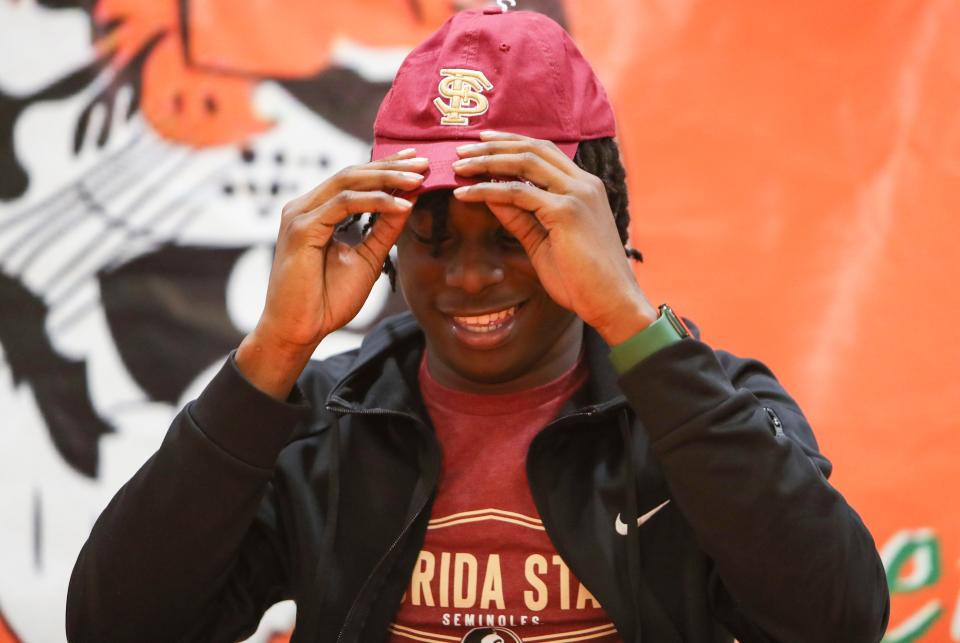 Junior Tawaski Abrams puts on his Florida State hat after committing to play for the Noles at Dunbar High School in Fort Myers on Thursday, Jan. 26, 2023.