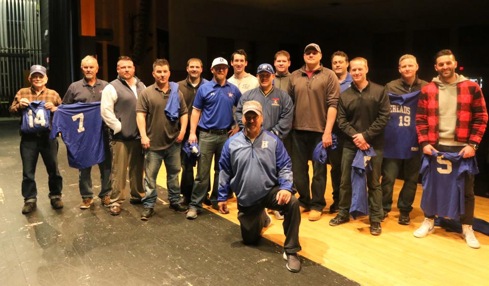 Head coach Jeff Limoncelli, front, poses with the 1999 state championship Horseheads baseball team and the father of one of the players who could not attend May 3, 2019 at Horseheads High School.