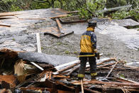 Southern Marin Fire Department members search a crushed house in the aftermath of a mudslide that destroyed three homes on a hillside in Sausalito, Calif., Thursday, Feb. 14, 2019. Waves of heavy rain pounded California on Thursday, filling normally dry creeks and rivers with muddy torrents, flooding roadways and forcing residents to flee their homes in communities scorched by wildfires. (AP Photo/Michael Short)