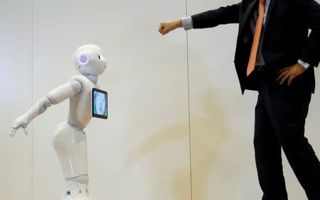 Board Director of Product Division for SoftBank Robotics Kazutaka Hasumi (R) performs with SoftBank's emotion-reading robot Pepper during a demonstration with the robot, to show its compatibility with Google's Android software, at the company's headquarters in Tokyo, Japan, May 19, 2016. REUTERS/Toru Hanai