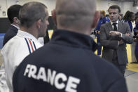 French President Emmanuel Macron, right, speaks with athletes as he visits France's National Institute of Sport, Expertise, and Performance (INSEP), prior to presenting his New Year's wishes to elite athletes ahead of the Paris 2024 Olympic and Paralympic Game, in Paris, Tuesday, Jan. 23, 2024. (Stephane De Sakutin/Pool Photo via AP)