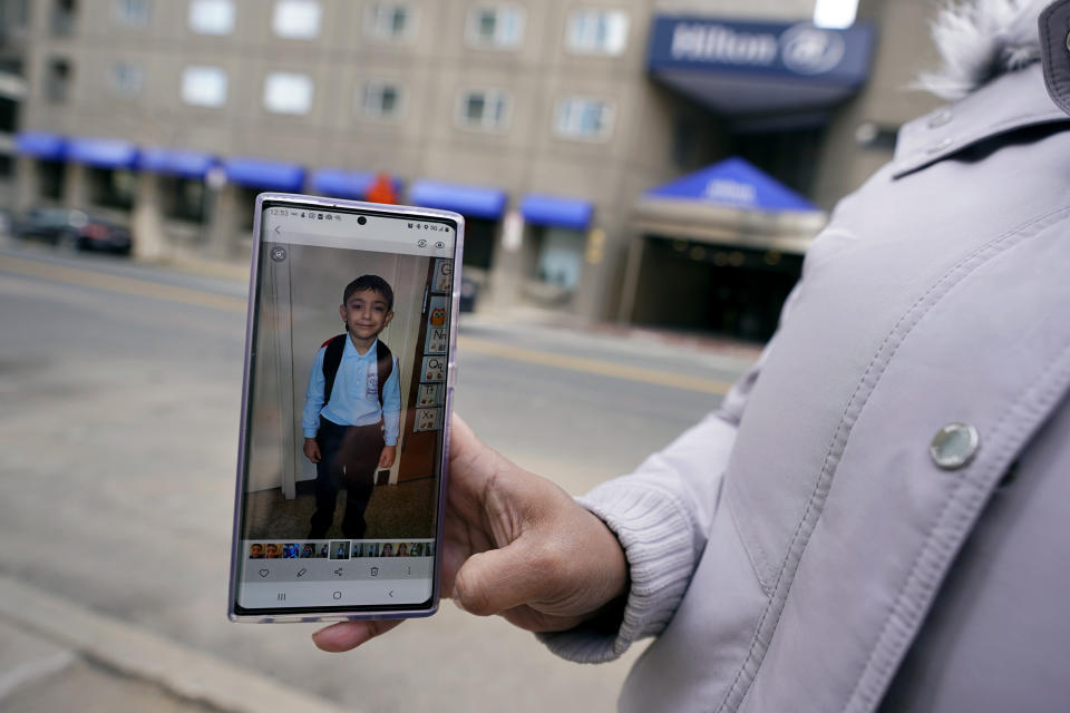 Hotel housekeeper Esther Montanez holds up a photograph of her five-year-old son Richard outside the Hilton Back Bay, Friday, March 5, 2021, in Boston. Montanez refuses to give up hope of returning to her cleaning job at the hotel, which she held for six years until being furloughed since March 2020 due to the COVID-19 virus outbreak. The single mother cannot bear the idea of searching for work that will almost certainly mean earning near the minimum wage. She earned about $23 a an hour at her job, plus tips, enough to provide a stable life for her son. (AP Photo/Charles Krupa)