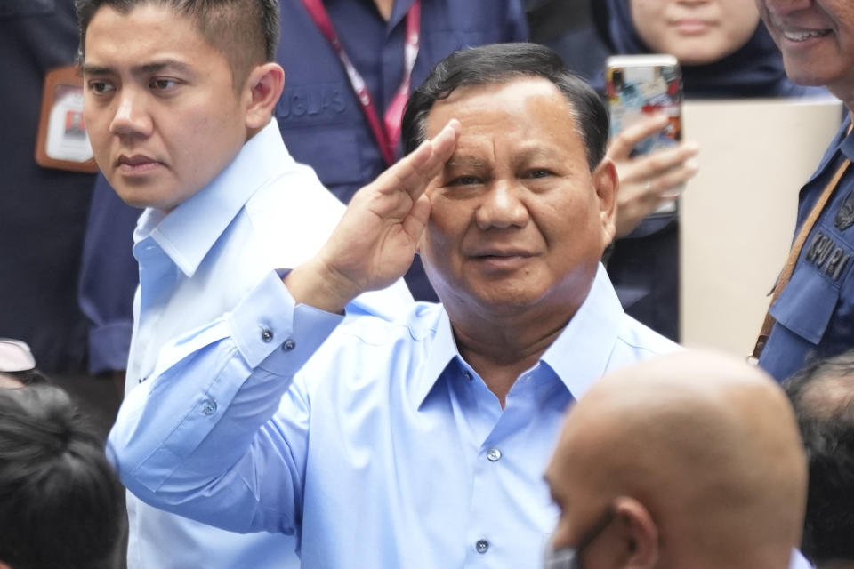 Presidential candidate Prabowo Subianto, center, salutes at photographers upon arrival to attend the "Declaration of Peaceful Election Campaign" at the General Election Commission Building, in Jakarta, Indonesia, Monday, Nov. 27, 2023. Presidential candidates in the world's third-largest democracy will kick off their campaign period on Nov. 28 ahead of the country's simultaneous legislative and presidential elections in February 2024. (AP Photo/Tatan Syuflana)