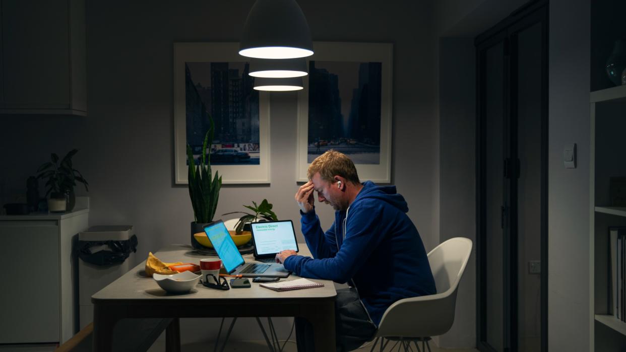  Man sitting at desk in dark. 