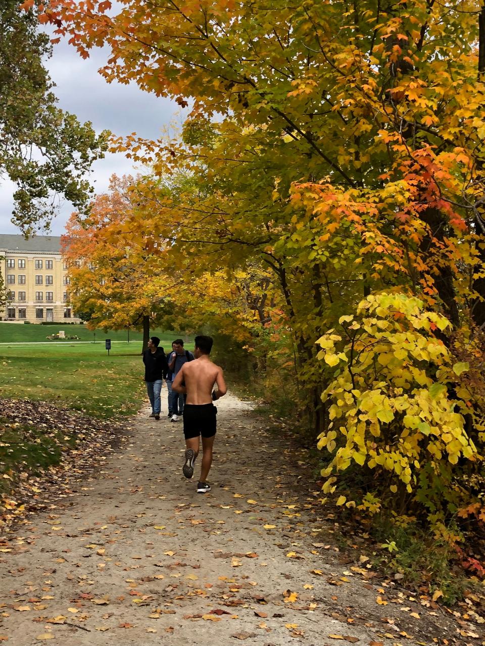 Fall colors appear on the path around Saint Mary's Lake on Saturday, Oct. 21, 2023, on the University of Notre Dame campus.
