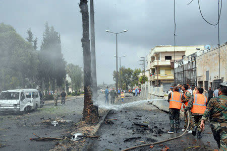 Men put off a fire after an explosion in the al-Zahraa neighbourhood of Homs city in this handout picture provided by SANA on May 23, 2017, Syria. SANA/Handout via REUTERS