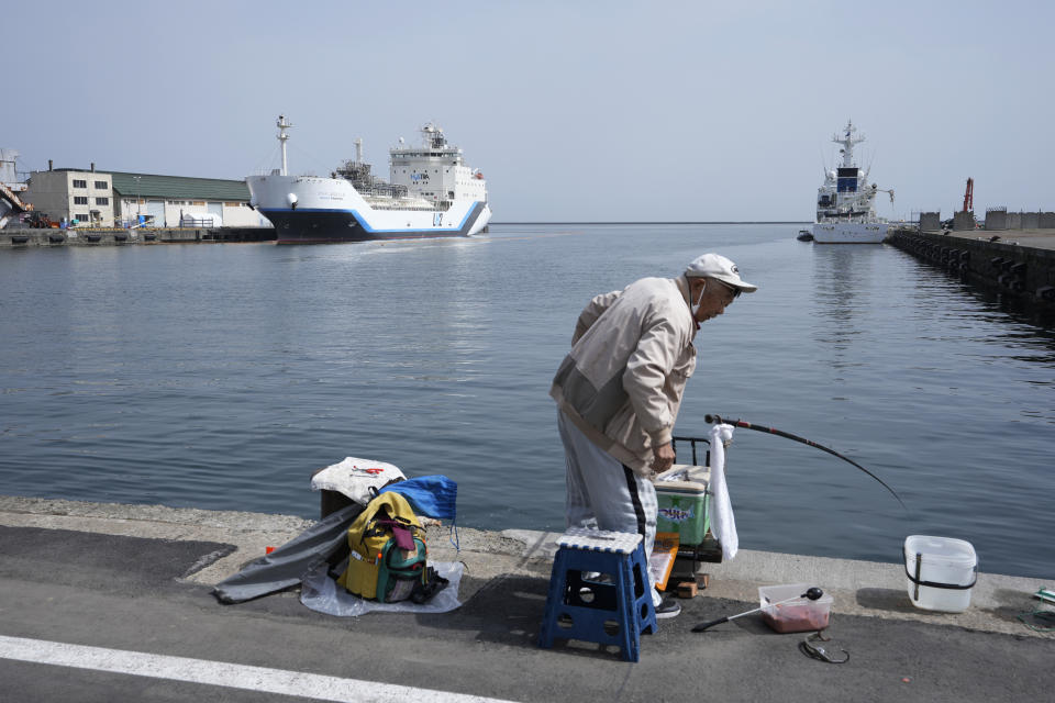 A man tries to catch fish at a pier where a liquefied hydrogen carrier is docked in Otaru, northern Japan, Friday, April 14, 2023. U.S. Energy Secretary Jennifer Granholm took a tour Friday on the Suiso Frontier, a liquefied hydrogen carrier, the day before the G-7 ministers' meeting on climate, energy and environment. (AP Photo/Hiro Komae)