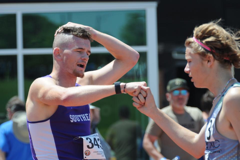 Southeast of Saline's Dylan Sprecker gives a fist bump to Wichita Trinity's Clay Shively after the 1,600-meters of the Class 3A state track and field championships Saturday, May 28, 2022, at Cessna Stadium in Wichita.