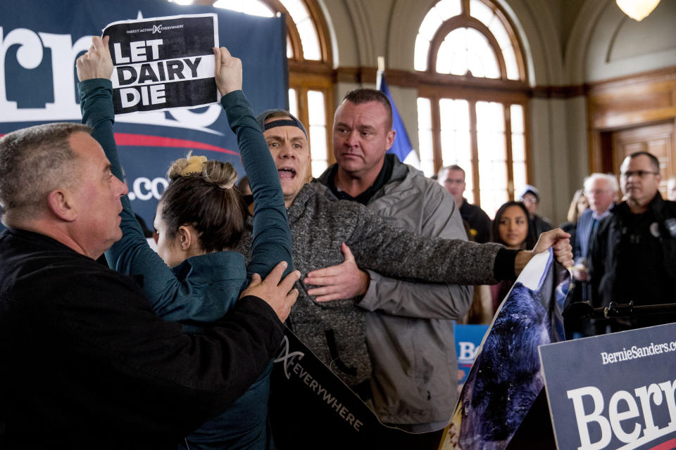 Democratic presidential candidate Sen. Bernie Sanders, I-Vt., at right, walks away as he is interrupted by protesters at a campaign stop at La Poste, Sunday, Jan. 26, 2020, in Perry, Iowa. (AP Photo/Andrew Harnik)