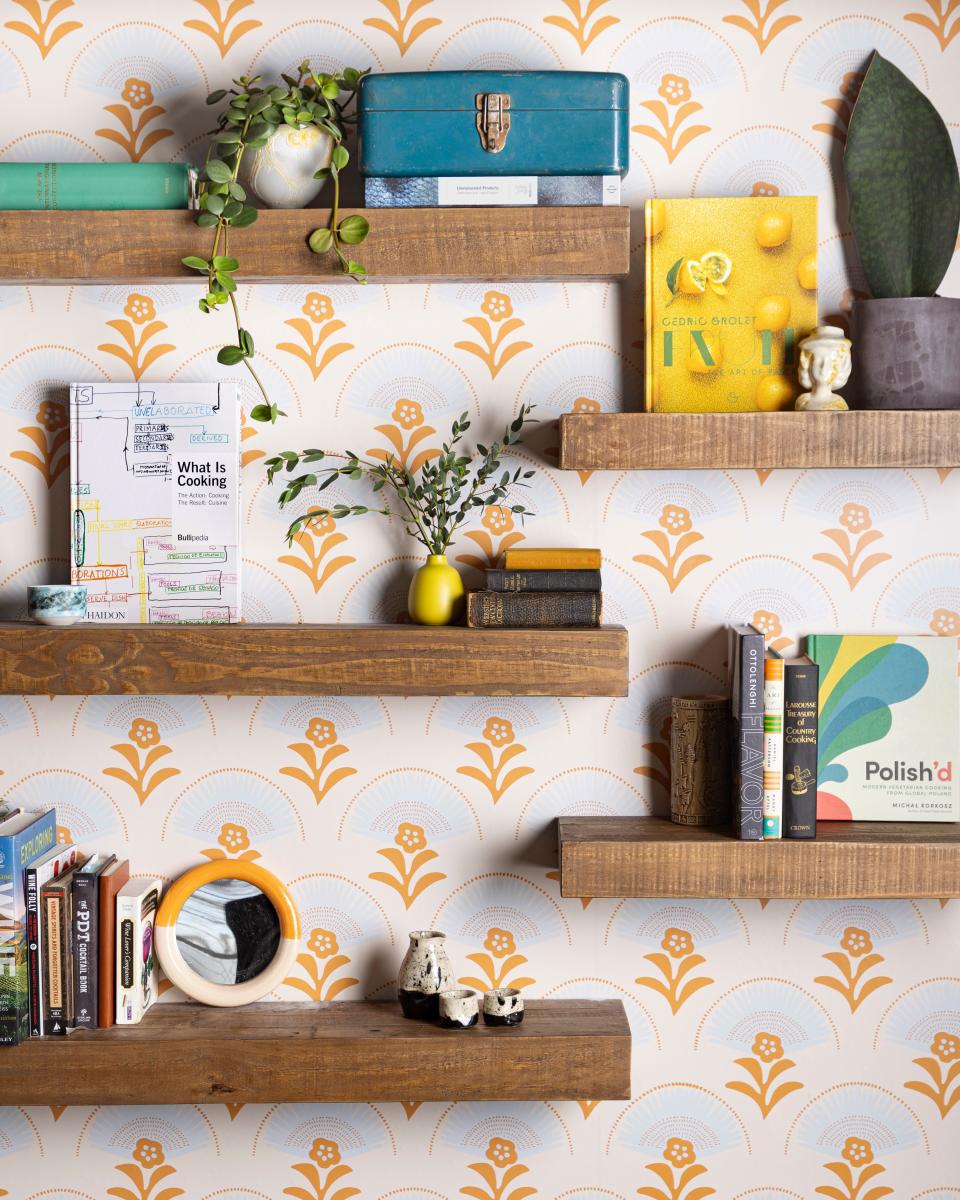 Custom wallpaper with EsterEv's logo line the walls, as do shelves holding keepsakes, plants and favorite cookbooks of chefs Dan Jacobs and Dan Van Rite.