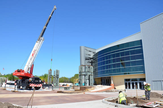 The steel skeleton for the "Space Shuttle Atlantis" exhibit's entranceway solid rocket boosters begins to rise off the ground at NASA’s Kennedy Space Center Visitor Complex in Florida.