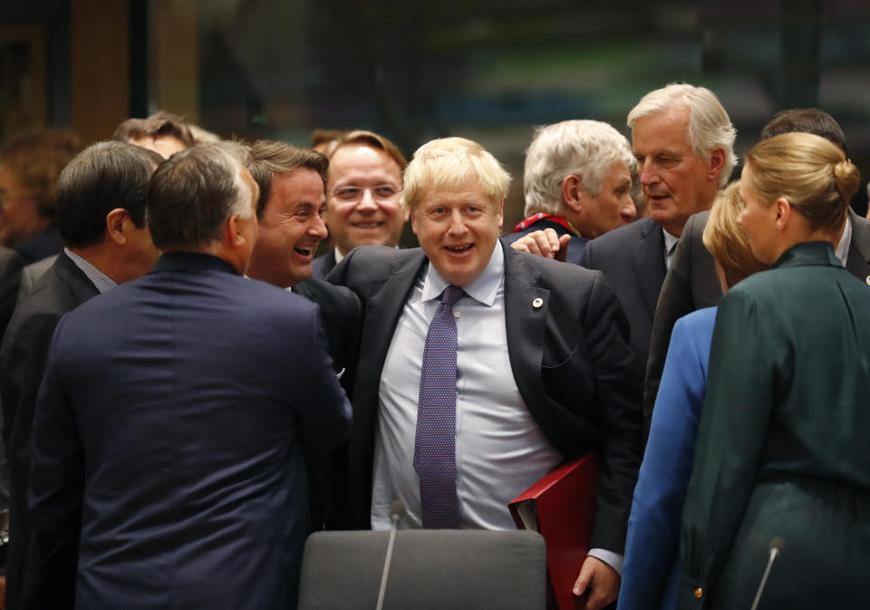 FILE - In this Thursday, Oct. 17, 2019 file photo British Prime Minister Boris Johnson, center, is greeted by Luxembourg's Prime Minister Xavier Bettel, center left, during a round table meeting at an EU summit in Brussels. (AP Photo/Frank Augstein)
