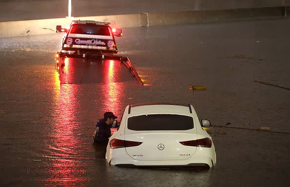 SUN VALLEY, CALIFORNIA - AUGUST 20: A tow truck driver attempts to pull a stranded car out of floodwaters on the Golden State Freeway as tropical storm Hilary moves through the area on August 20, 2023 in Sun Valley, California. Southern California is under a first-ever tropical storm warning as Hilary impacts parts of California, Arizona and Nevada. All California state beaches have been closed in San Diego and Orange counties in preparation for the impacts from the storm which was downgraded from hurricane status. (Photo by Justin Sullivan/Getty Images)