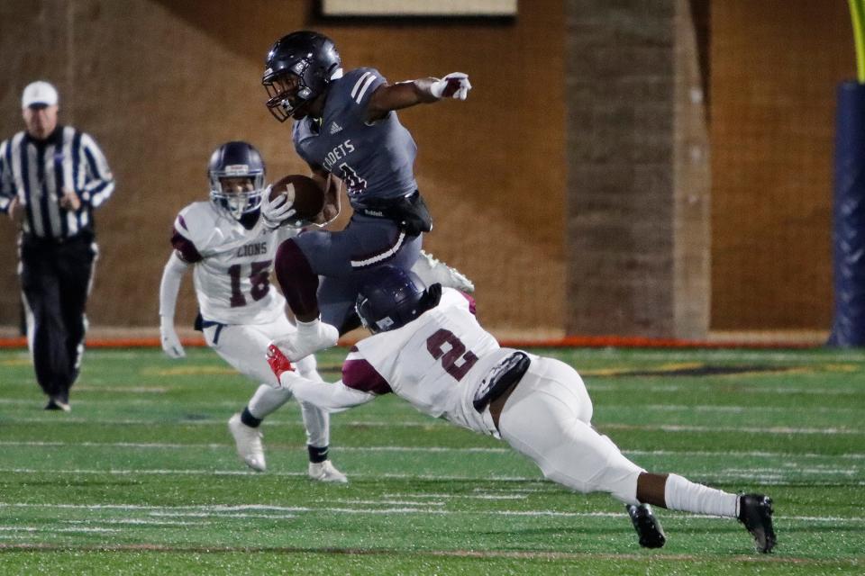 Benedictine's Justin Thomas (4) runs while Luella's Marquise Strickland (2) tries to tackle him in playoff game at Memorial Stadium on Friday, Nov. 19, 2021.