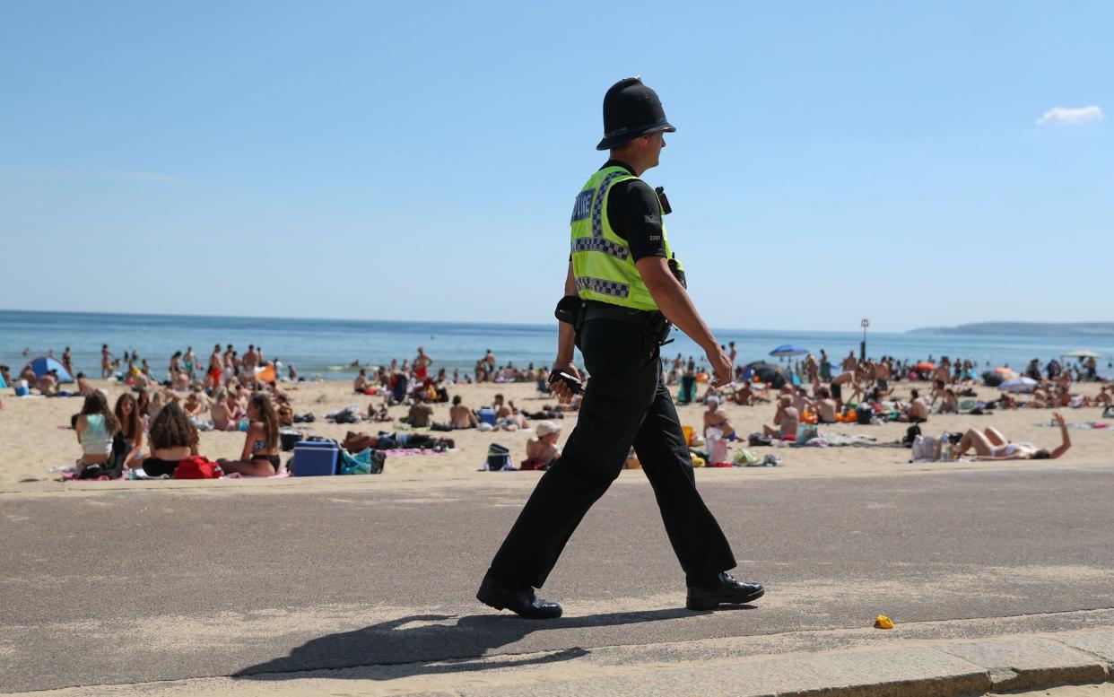 A police officer patrols along the beach in Bournemouth, Dorset, as the public are being reminded to practice social distancing following the relaxation of the coronavirus lockdown restrictions in England - Two-metre social distancing rule based on outdated science that may have overestimated coronavirus risk by up to fifteen times - PA