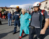 <p>An elderly woman is escorted by rescuers following an earthquake, in Accumoli, central Italy, Wednesday, Aug. 24, 2016. A devastating earthquake rocked central Italy early Wednesday, collapsing homes on top of residents as they slept. (AP Photo/Andrew Medichini) </p>