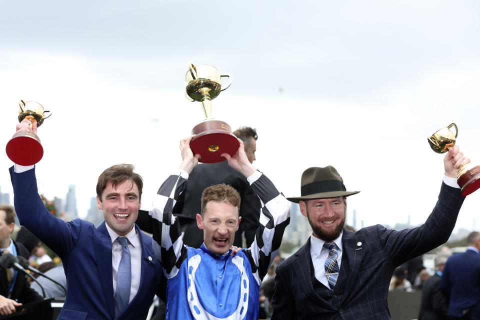 Jockey Mark Zahra, center, and trainers David Eustace, left, and Ciaron Maher show off their trophies after Gold Trip won the Melbourne Cup horse race in Melbourne, Australia, Tuesday, Nov. 1, 2022. (AP Photo/Asanka Brendon Ratnayake)