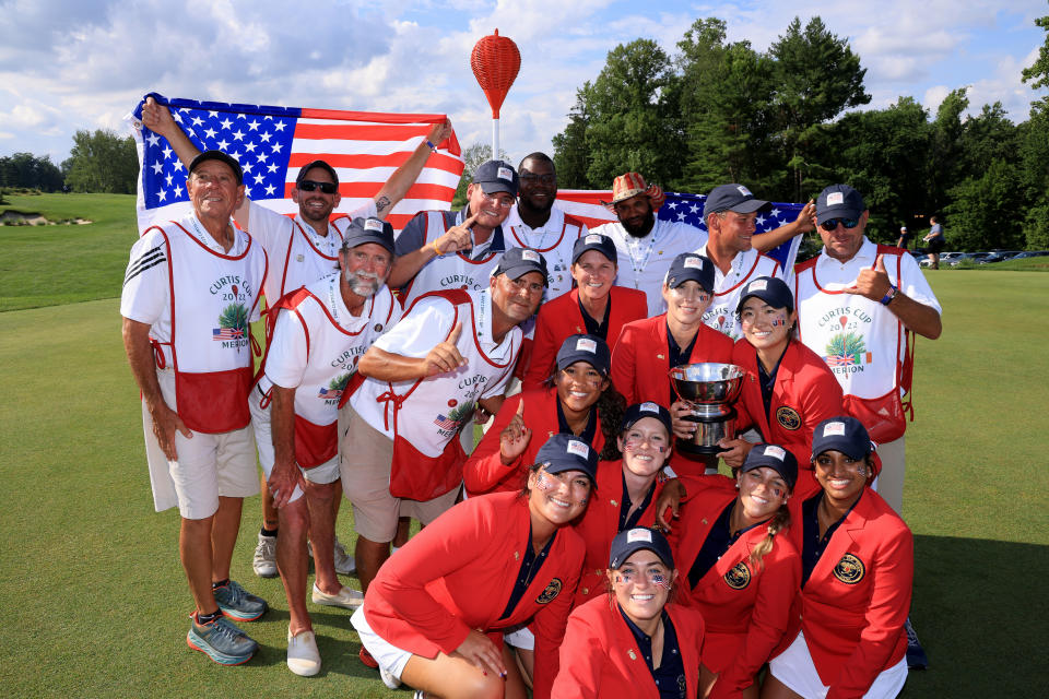 The United States team pose with the Curtis Cup and their team caddies after the singles matches on day three of The 2022 Curtis Cup at Merion Golf Club on June 12, 2022 in Ardmore, Pennsylvania. (Photo by David Cannon/Getty Images)