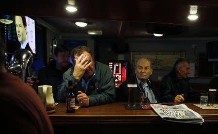 Britain's Deputy Prime Minister Nick Clegg is seen on a television screen as patrons socialise in the Kay Park Tavern, a pub near the main business district in Kilmarnock, Scotland March 26, 2014. REUTERS/Suzanne Plunkett