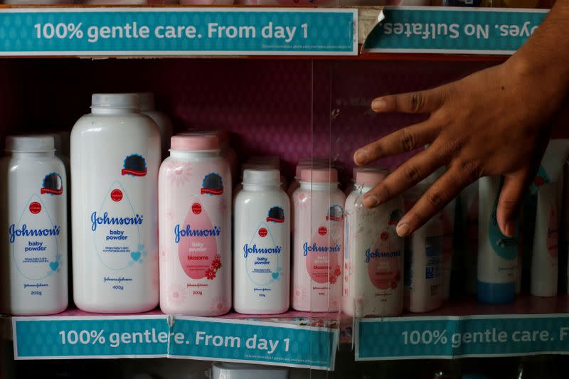 FILE PHOTO: A worker closes a glass cabinet of Johnson & Johnson baby powder bottles at a medical store in Kolkata