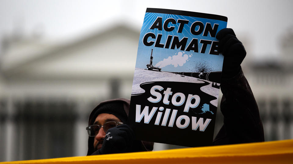 A demonstrator holds a sign reading: Act on climate. Stop Willow.