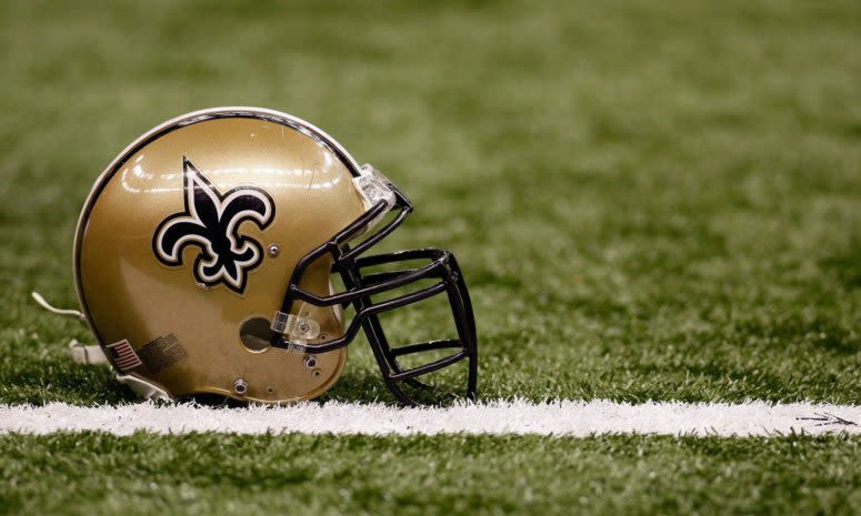 A closeup of a New Orleans Saints helmet on the football field.