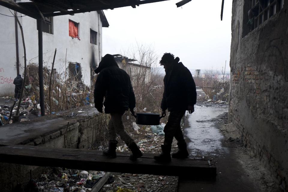 Migrants carry water back to an abandoned warehouse where they and other migrants took refuge in Belgrade, Serbia, Wednesday, Feb. 1, 2017. Hundreds of migrants have been sleeping rough in freezing conditions in central Belgrade looking for ways to cross the heavily guarded EU borders. (AP Photo/Muhammed Muheisen)