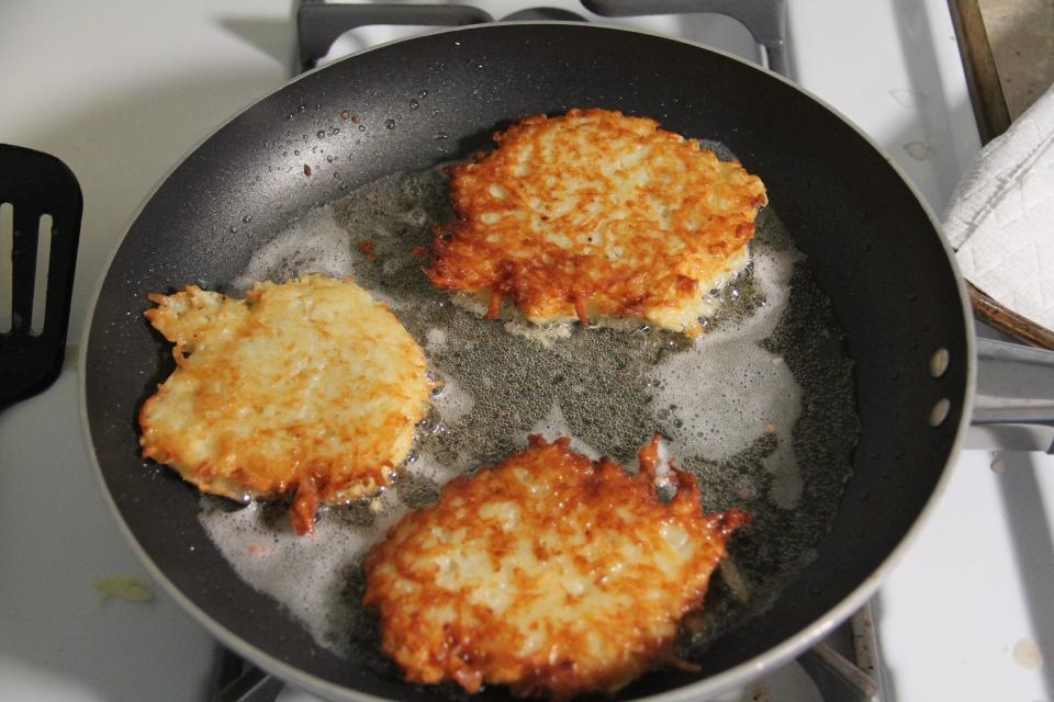 Martha Stewart's latkes frying in a frying pan.