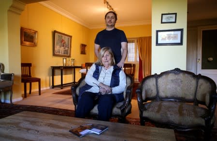 Guillermo Galia poses for a picture with his mother Slivia at his home, in Buenos Aires