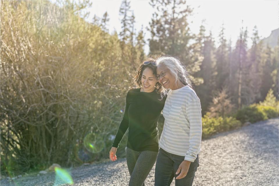 A woman walks on a hiking trail with her mother