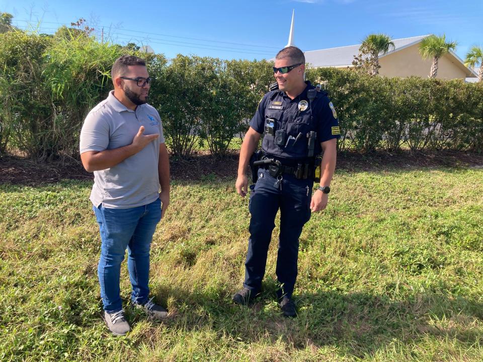 Norberto Garcia (left), and Port St. Lucie Police Officer Joseph Rathnam (right) on Oct. 23, 2023, at the scene where two days earlier they helped rescue an 81-year-old man from a Toyota Prius that ran into a pond off Southwest Oakner Street in Port St. Lucie.