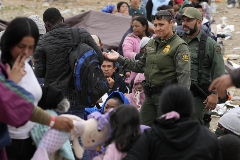 Agentes de la Patrulla Fronteriza de Estados Unidos se desplazan etre una multitud de migrantes que llevan días aguardando entre dos muros fronterizos para solicitar asilo, mientras deciden quién será el siguiente en ser procesado, el viernes 12 de mayo de 2023, en San Diego. Cientos de migrantes siguen esperando entre los dos muros, muchos de ellos desde hace días. Estados Unidos inició una nueva política de manejo de la inmigración a partir del viernes, poniendo fin a una medida que restringió el asilo durante tres años e implementando una serie de nuevas normas estrictas que el gobierno del presidente Joe Biden espera estabilizarán la frontera entre Estados Unidos y México y orillarán a los migrantes a solicitar ingresar vía internet desde el país en el que vivan, con lo que no tendrán que hacer el peligroso viaje hacia el norte. (AP Foto/Gregory Bull)