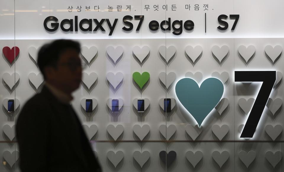 A man walks by an advertisement of the Samsung Electronics Galaxy S7 Edge and S7 smartphones in Seoul, South Korea, Friday, Jan. 6, 2017. Samsung Electronics Co. said Friday that its profits in the last quarter of 2016 surged 50 percent to the highest level in more than three years, despite the Galaxy Note 7 fiasco. (AP Photo/Lee Jin-man)