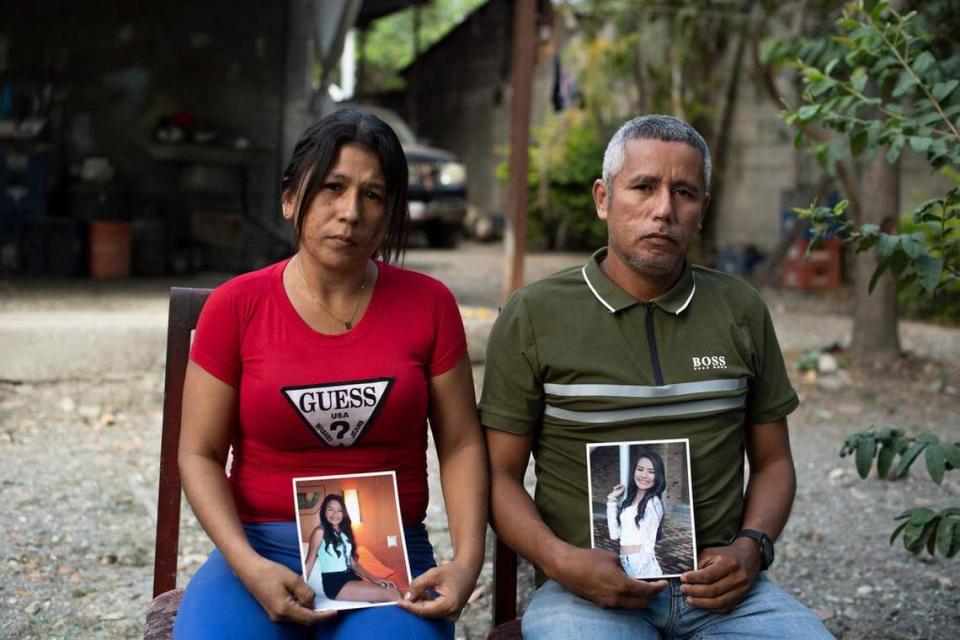 Mileidys Torrealba and Eduard José Falcón sit with photos of their daughter, Eduarlis Falcón, 20, who was killed alongside another young woman in her home in La Misión, Venezuela, on Feb. 27, 2021.
