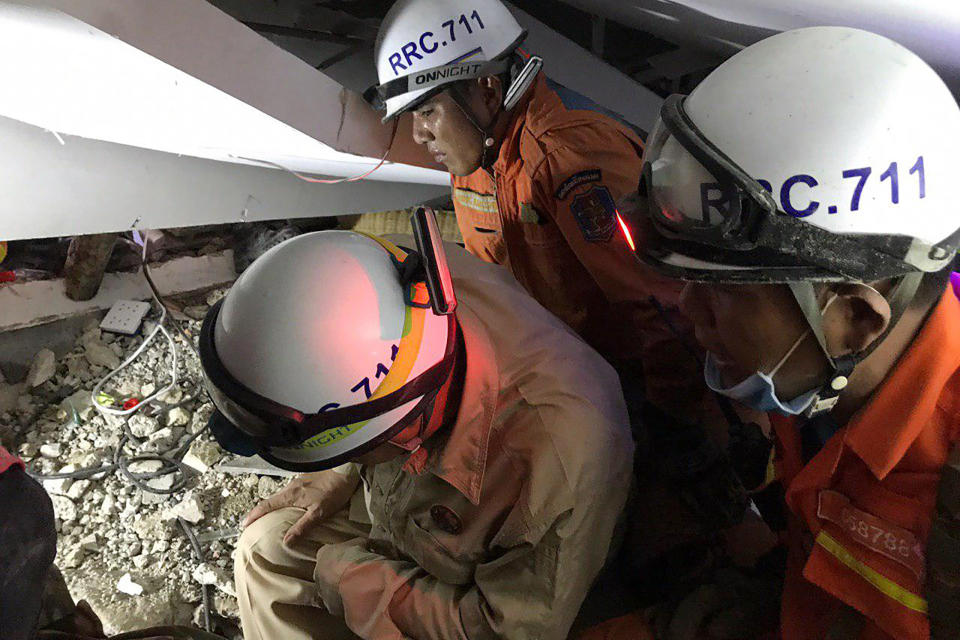 In this photo provided by the Kep Provincial Authority, emergency workers conduct a recovery operation inside a collapsed building in Kep province, southern Cambodia, Saturday, Jan. 4, 2020. The seven-story building under construction collapsed Friday while around 20 workers were inside. (Kep Provincial Authority via AP)