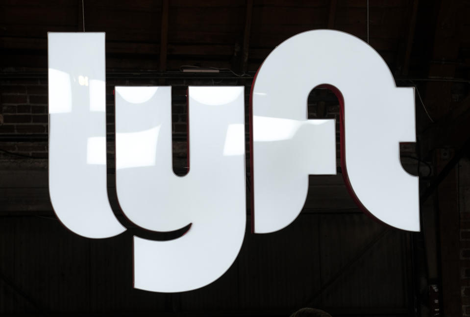FILE - This March 29, 2019, file photo shows a sign for Lyft in Los Angeles. Google's self-driving car spinoff Waymo is teaming up with Lyft in Arizona to attempt to lure passengers away from ride-hailing market leader Uber. (AP Photo/Ringo H.W. Chiu, File)