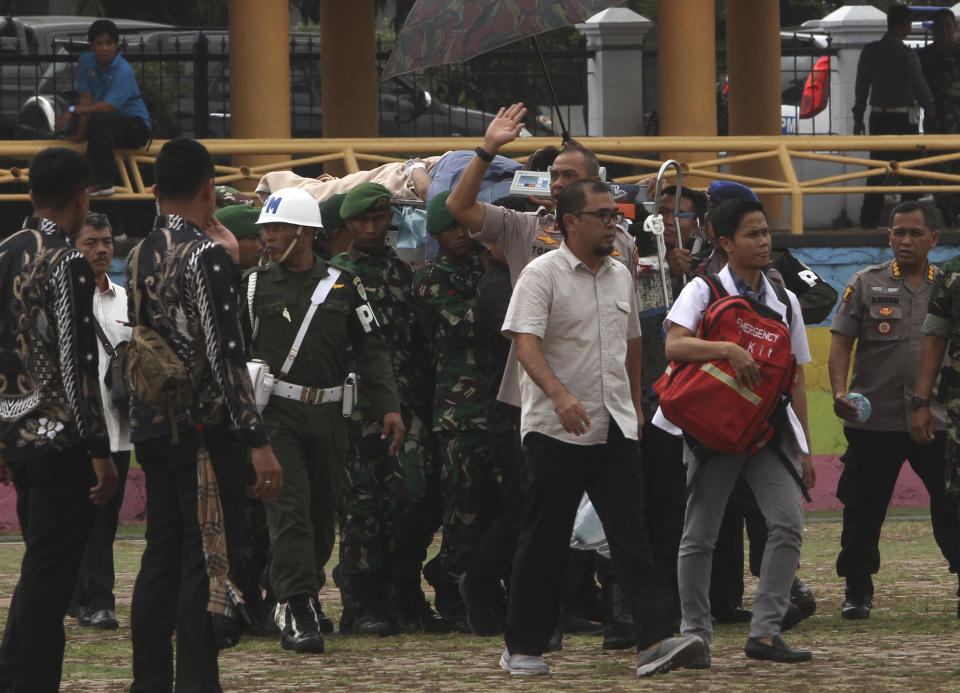 Soldiers carry Indonesian Coordinating Minister for Politics, Law and Security Wiranto on a stretcher to a waiting helicopter to be evacuated to Jakarta, in Pandeglang, Banten province, Indonesia, Thursday, Oct. 10, 2019. Indonesian police officials say Wiranto and two other people, including a local police chief, have been wounded by a knife-wielding man and taken to a hospital during a visit to a western province. (AP Photo/Rafsanjani)