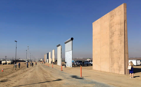 People look at prototypes of a border wall Thursday, Oct. 26, 2017, in San Diego - Credit: AP