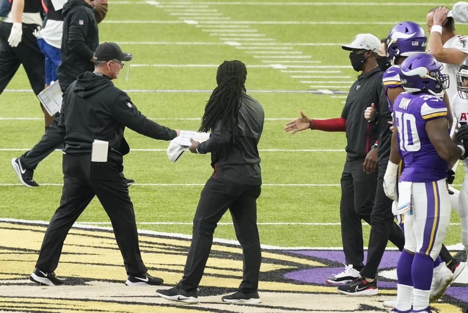 Minnesota Vikings head coach Mike Zimmer, left, greets Atlanta Falcons head coach Raheem Morris, right, after an NFL football game, Sunday, Oct. 18, 2020, in Minneapolis. The Falcons won 40-23. (AP Photo/Jim Mone)