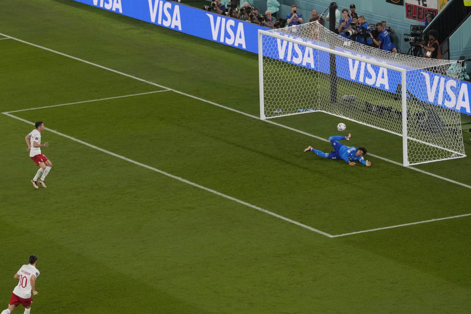 Mexico's goalkeeper Guillermo Ochoa saves on a penalty kick by Poland's Robert Lewandowski during the World Cup group C soccer match between Mexico and Poland, at the Stadium 974 in Doha, Qatar, Tuesday, Nov. 22, 2022. (AP Photo/Darko Vojinovic)