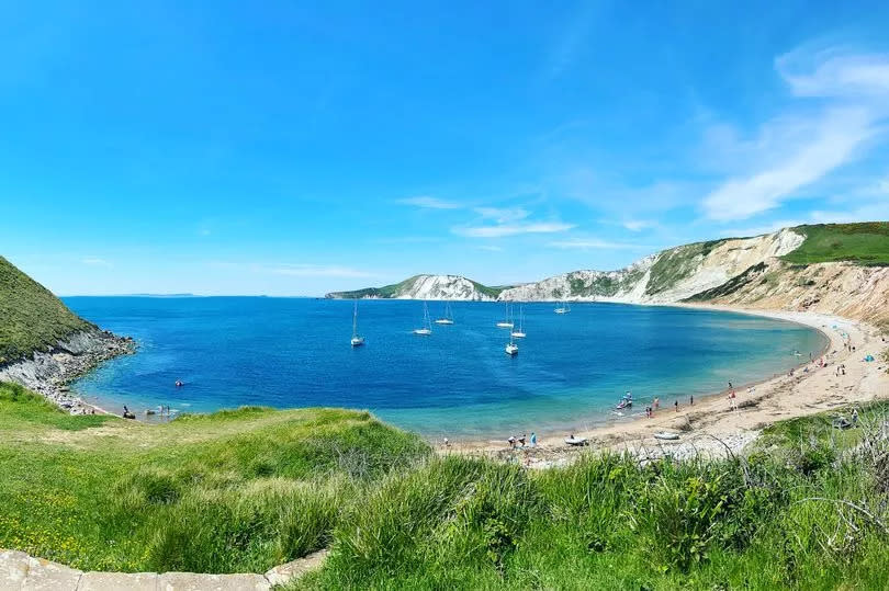 A photo showing the cove of Worbarrow Bay and blue skies