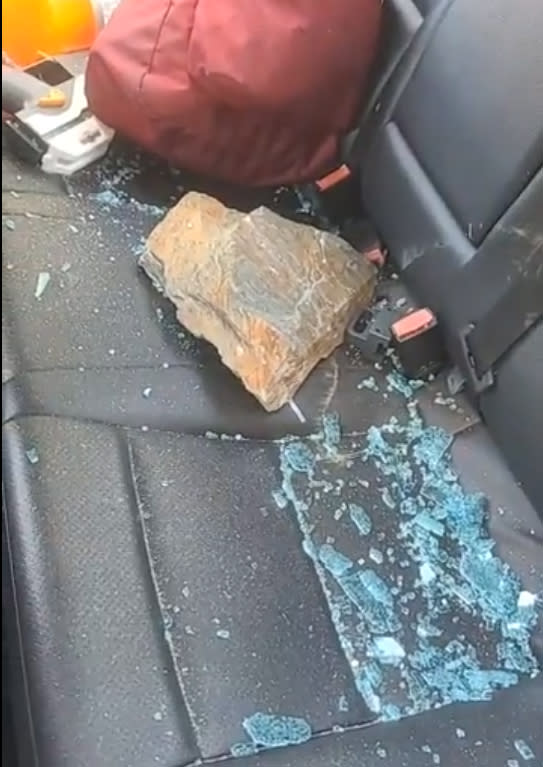 A large stone with sharp edges in the back seat of the car. (CJ Jones / via Facebook)
