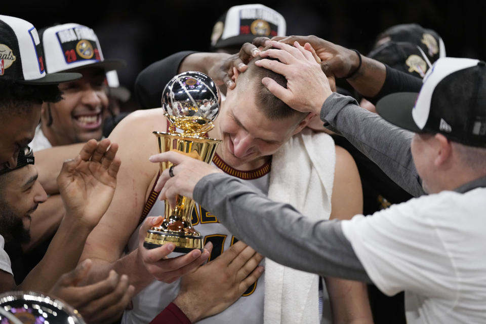 Denver Nuggets center Nikola Jokic is mobbed by teammates after accepting the series MVP trophy in after Game 4 of the NBA basketball Western Conference Final series Monday, May 22, 2023, in Los Angeles. (AP Photo/Ashley Landis)