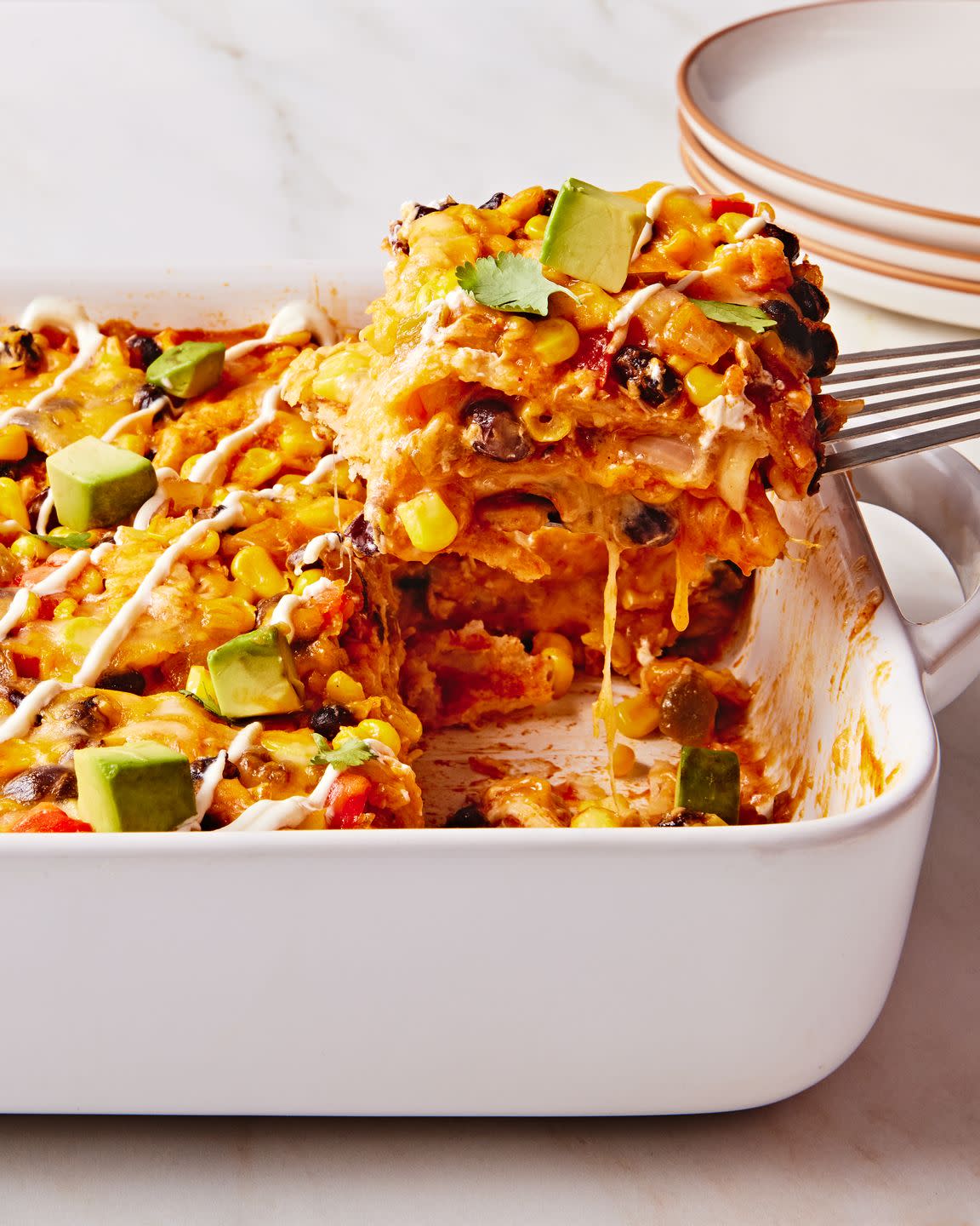 enchilada fillings in a casserole topped with avocado cubes