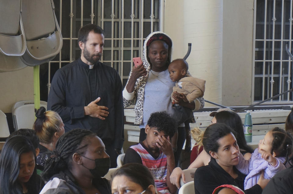 The Rev. Brian Strassburger, a Jesuit priest, talks with Rose, a Haitian migrant holding her 1-year-old son, in the Casa del Migrante shelter in Reynosa, Mexico, on Dec. 15, 2022. Strassburger and two fellow Jesuit priests go across the border twice weekly to celebrate Mass and bring some comfort at the shelter, which is at more than double its capacity as migrants cram this border city. (AP Photo/Giovanna Dell'Orto)