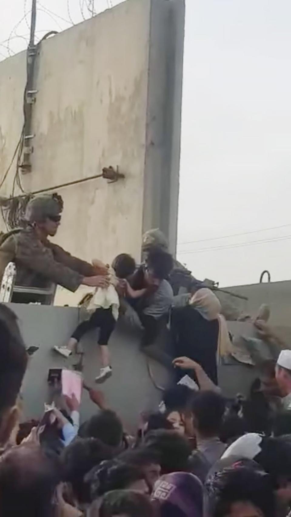 Afghan mother and child escape over wall in Kabul