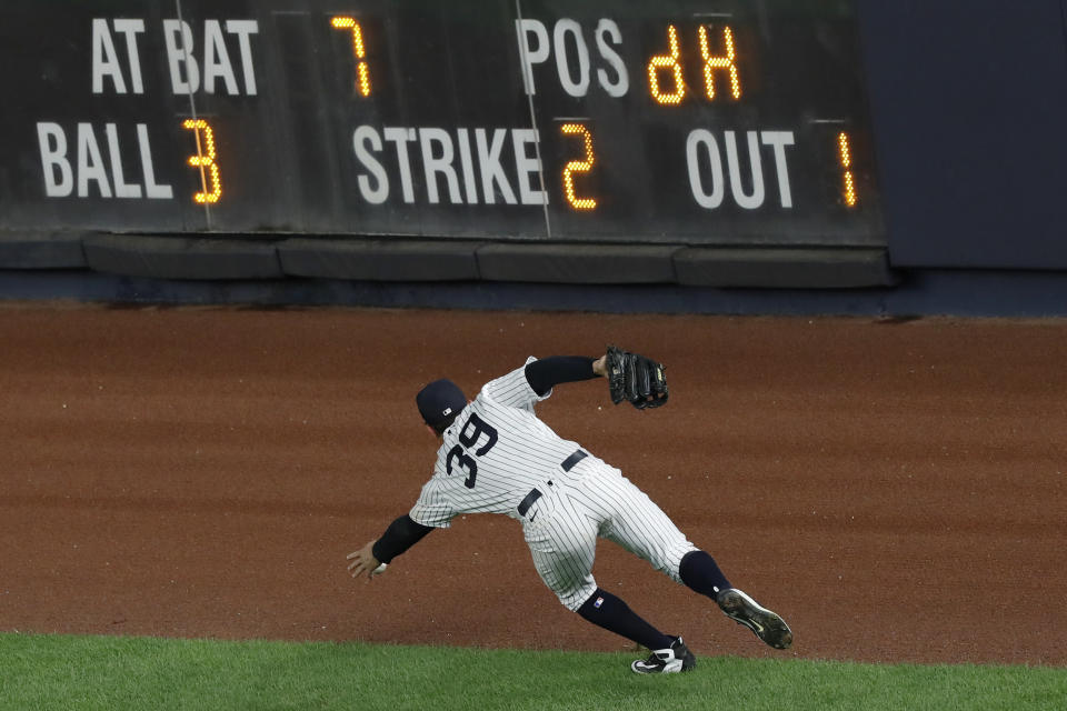 New York Yankees right fielder Mike Tauchman barehands the ball on a double off the wall by Boston Red Sox's Christian Vazquez during the ninth inning of a baseball game Sunday, Aug. 16, 2020, in New York. (AP Photo/Kathy Willens)